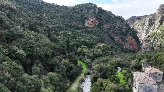 Aerial drone footage capturing a flight around the historic moni Sotiros Monastery on the rocky slopes of Vyros Gorge near Kardamyli, Greece. This breathtaking view highlights the rugged beauty and ri