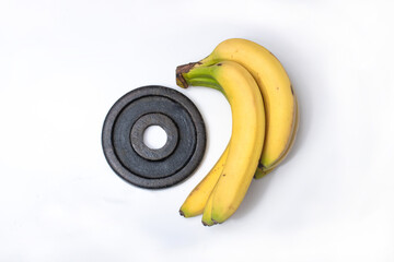 Dumbbells and a banana, symbolizing the balance between fitness training and healthy nutrition for a well-rounded fitness lifestyle.