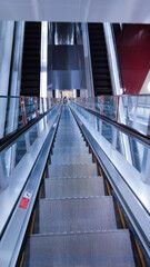 a very long escalator in an above-ground train station platform