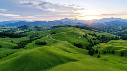 Obraz premium Sunset over rolling green hills, rural landscape, idyllic scenery