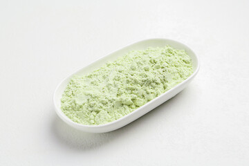 Dry wasabi powder on white textured table, closeup