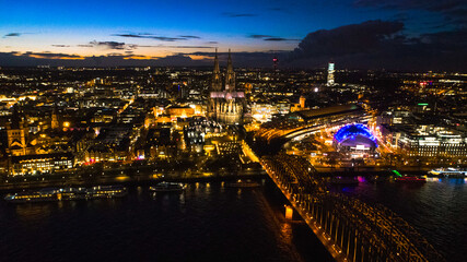Obraz premium Night drone view of centrum of Cologne in Germany by sunset. Seen showing famous Dom-Cathedral, bridge , rive Rhein and Opera all in downtown