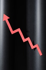 One red paper arrow on black background, top view