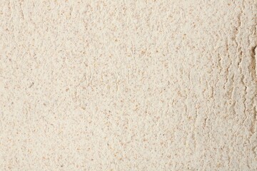Brown rice flour as background, closeup view