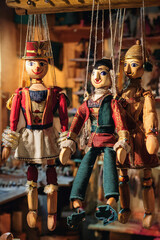 Obraz premium Marionetas de madera colgadas en un taller de artesanía, iluminadas por luz cálida