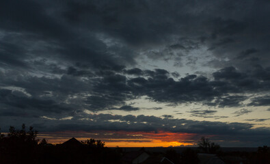 Landscape at sunset. Tragic gloomy sky. Panorama. Crimson twilight.