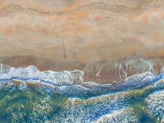 Birds eye view of the surf rolling on the beach at sunrise. Taken by drone from 200 ft. the location is on the east coast of North Carolina.