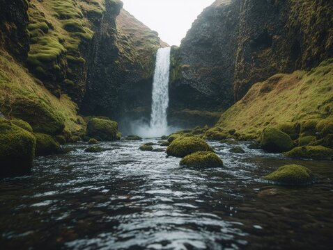 A serene waterfall nestled amidst lush greenery and rock formations, with a forested backdrop.