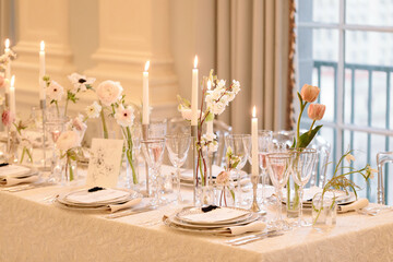 Elegant dining setup with candles and floral arrangements in a stylish venue during an afternoon event