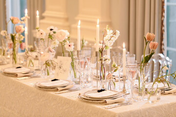 Elegant table setting with candles and floral arrangements for a special event indoors