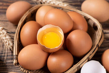raw chicken eggs,Broken egg with yolk on wooden table.