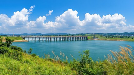 Scenic View of Bridge Over Calm Water Under Clear Blue Sky Surrounded by Lush Greenery