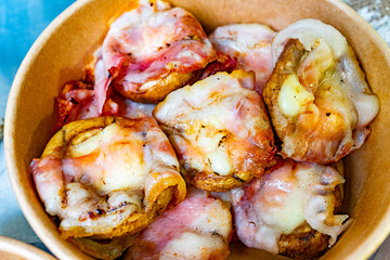 Savory potato cups topped with cheese and bacon served in a bowl
