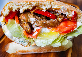 Delicious sandwich filled with grilled meat and fresh vegetables