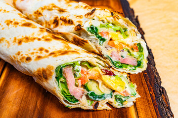 Delicious vegetable wrap with fresh ingredients on a wooden board