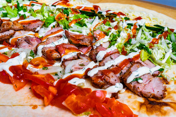 Delicious shashlik in pita bread with fresh vegetables and sauce