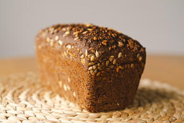Sourdough bread, freshly baked and still warm, are stacked on a wooden surface. The bread are...