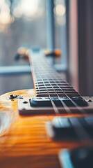 Fototapeta premium Close-up of an electric guitar with a wooden finish and soft sunset lighting.
