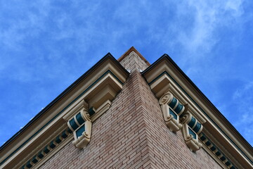 Upward angle of classical building. Corner shot with clear blue sky.