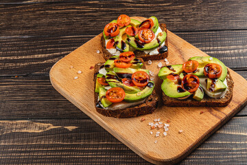 Healthy avocado toast with cherry tomatoes on rye bread for brunch