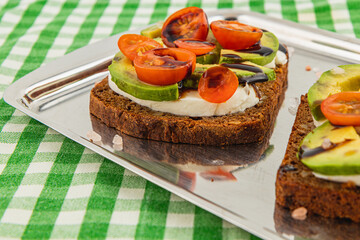Delicious open-faced sandwich with fresh vegetables on a metal tray