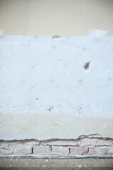 Weathered wall showing layers of paint and brick in Cremona, Italy