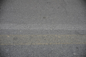 Continuous yellow stripe dividing the asphalt road