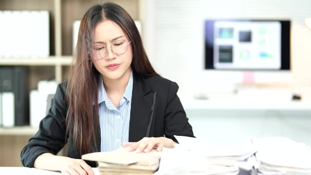 Professional businesswoman experiencing workplace stress, frantically searching through extensive paperwork while looking overwhelmed and exhausted at office desk