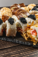 Creative sushi platter featuring various rolls and toppings served on slate