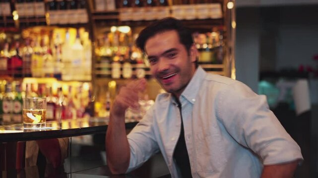 Smiling smart man drinking cocktail in Old fashioned with enjoy dancing in cheers with friends or stranger special vibrant beverage at nightclub on Friday meeting at luxurious counter bar. Vinosity.