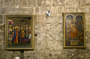 Paintings with religious themes hang on wall in Church of the Holy Sepulchre in Jerusaslem old city...