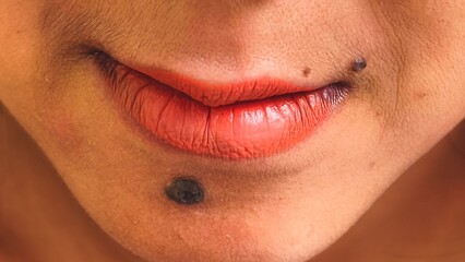 A close-up portrait highlighting the vibrant red lips and unique mole placement, accentuating natural features