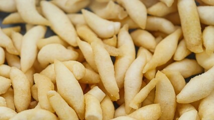 Savory Cork Egg Cheese Sticks. These golden-yellow snacks boast a crispy and crunchy texture, making them a delightful treat. The intricate details of the crackers create a visually appealing pattern.