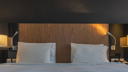 The double bed is covered with white sheets. The pillows are neatly arranged on the headboard. The...
