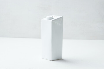 Simple White Carton Milk Box on a Clean Surface, Suitable for Beverages or Liquids, Captured in Bright Natural Light