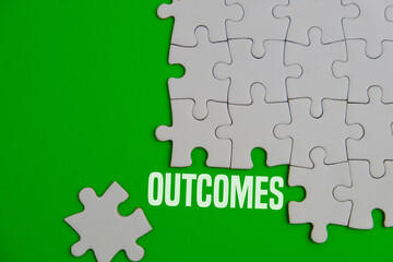 Close up of the last jigsaw puzzle piece with word outcomes