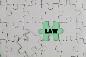Fototapeta premium Word Law made of colored with white puzzle, composition isolated over the green background