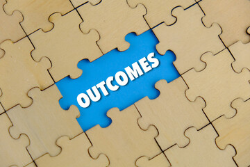 Fototapeta premium Close up of the last jigsaw puzzle piece with word outcomes 