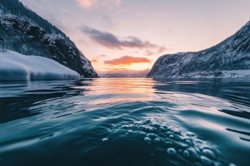 Stunning sunset over snowy fjord in Norway captured from the water's edge, Beautiful sunset Norway snowy fjord shot from water surface with underwater transition