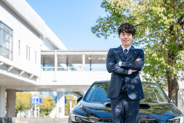 車の前に立つビジネスマン