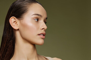 Profile of a young model with glowing skin and long hair, styled in a natural and elegant manner...