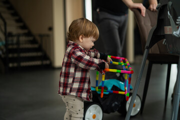 Little toddler baby boy playing with development toys for developing movements in different colors...