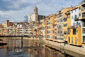 Girona Spain - 25 April 2024 - Colourful houses along Onyar River in front of cathedral in Girona