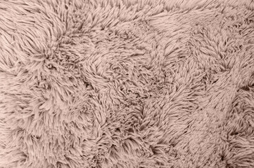 A soft, fluffy beige blanket creates a cozy texture perfect for adding warmth and comfort to any...