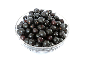 Fresh ripe aronia berries in a glass bowl, white background, isometric view