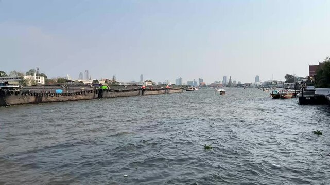 A tugboat carrying a sand barge along Chao Phraya river.