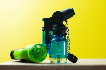 Blue and green lighters on a bright yellow background