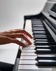 Fototapeta premium グレーの無機質背景とともに、滑らかな手の動きで奏でられるピアノの音楽 