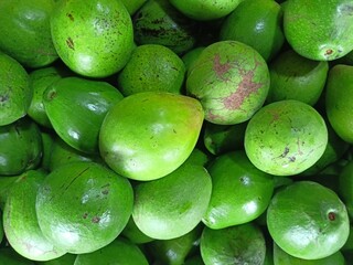 Avocados are green in color, shaped like pumpkins and have large seeds.