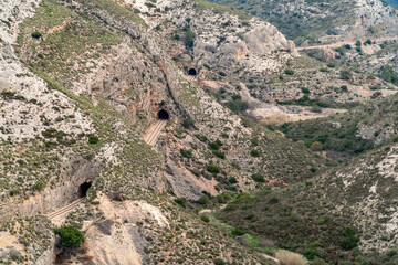 Fototapeta premium Mountainous landscape with a railway track and tunnels